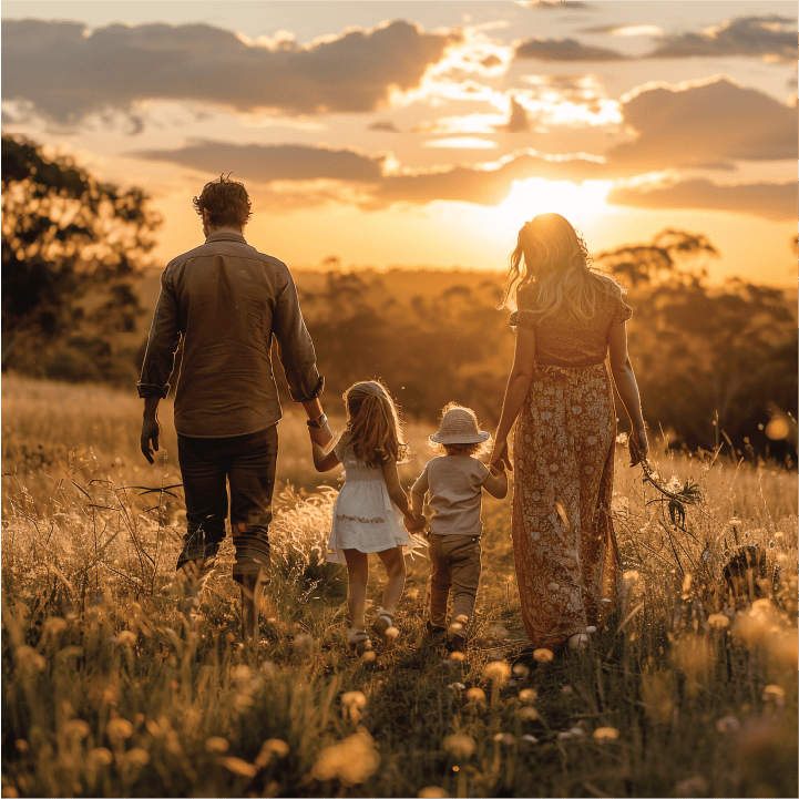  Family walking together during sunset in a field, symbolizing unity and emotional support through counseling.