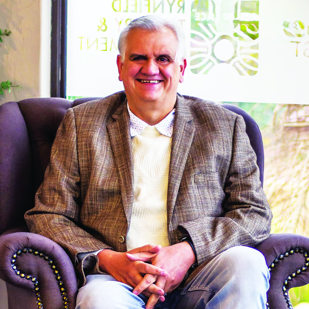 Smiling counseling psychologist sitting in an armchair, offering professional mental health support in Benoni.